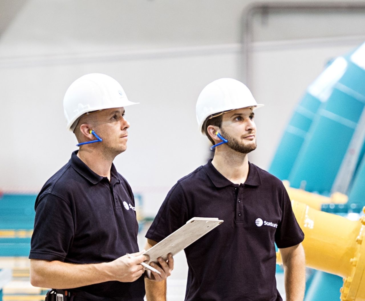 Two Statkraft employees inside the machine hall of Erzhausen pump storage power plant.